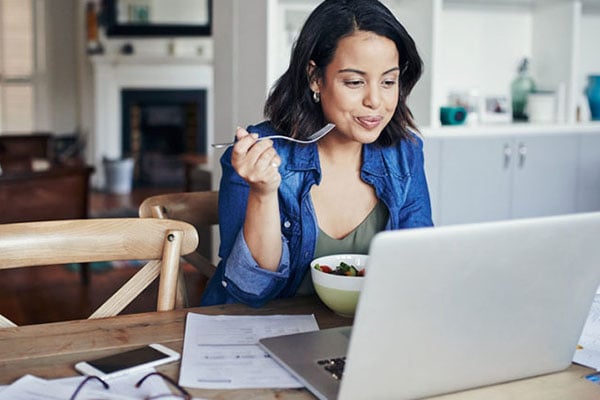 营养——拿着笔记本电脑的妇女吃健康早餐|加拿大克利夫兰诊所BOB买球平台