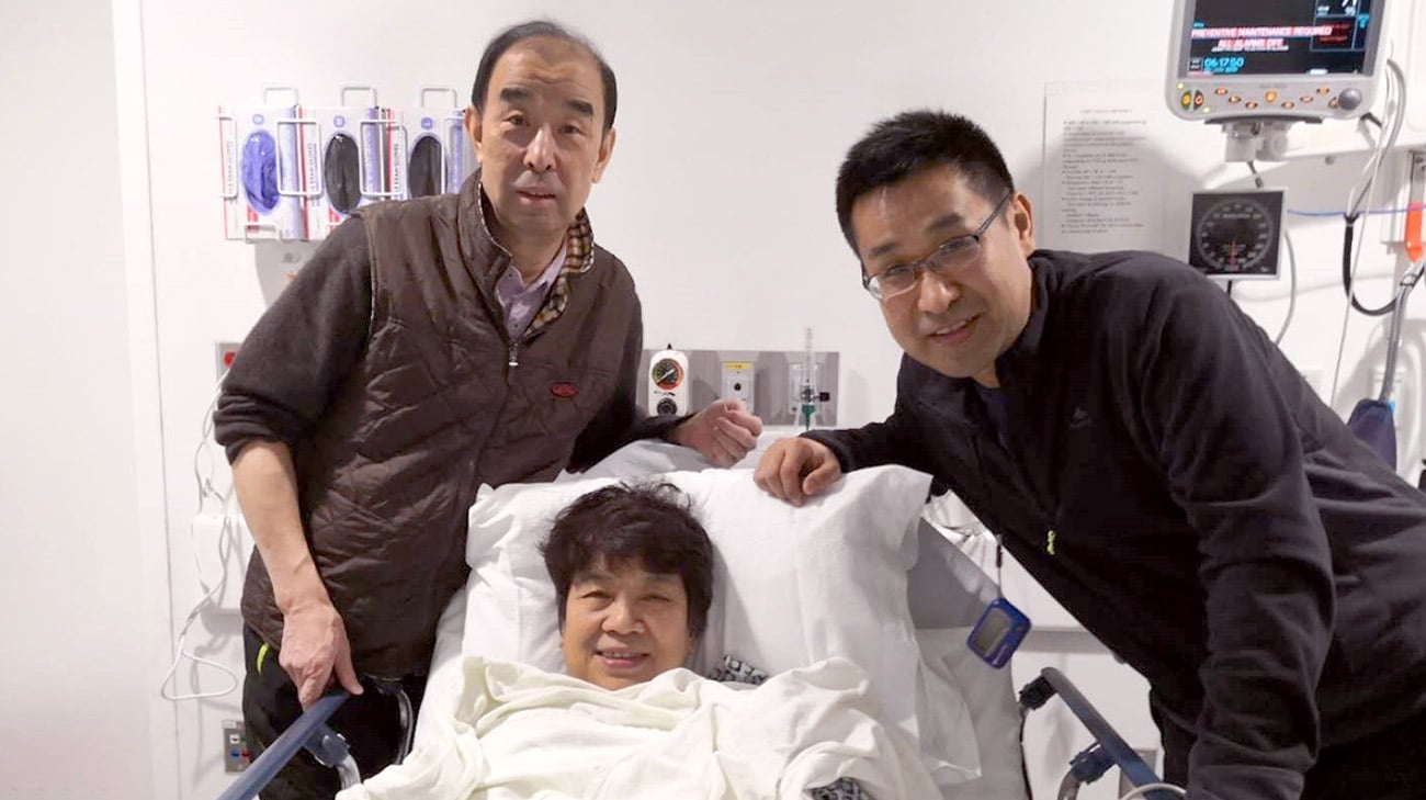 吴月仙(中)于2019年1月成功接受微创二尖瓣修复手术。她的丈夫志刚(左)和儿子晓友(右)和她一起从上海来到克利夫兰。