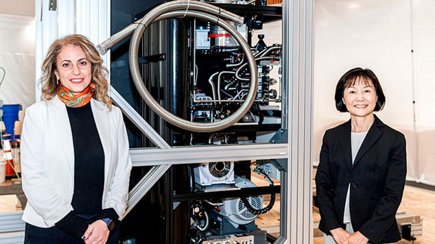 医学博士Lara Jehi和Zhou Ruoyi博士站在IBM量子系统一号的一台机器前。